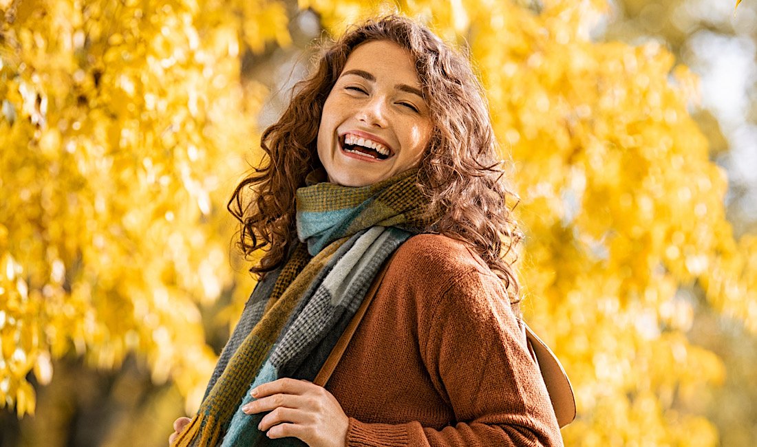 Happy girl laughing in autumn with beautiful skin.